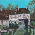 Historic half-timbered watermill by a river with bridge, boat, and trees.